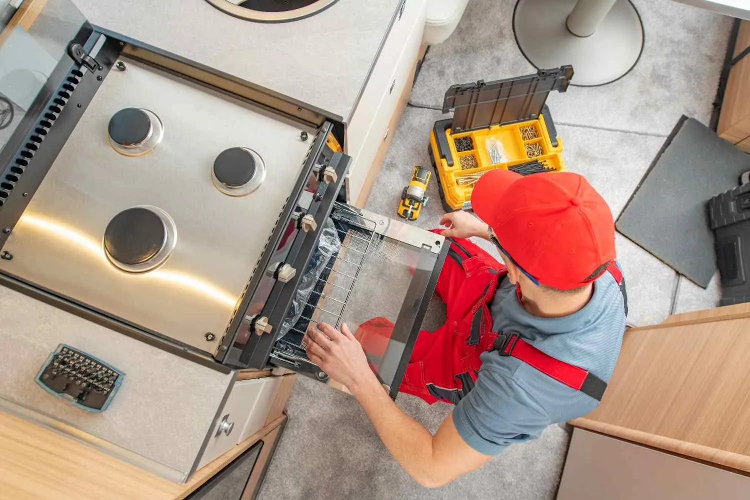 Technician repairing a built-in oven in a home kitchen